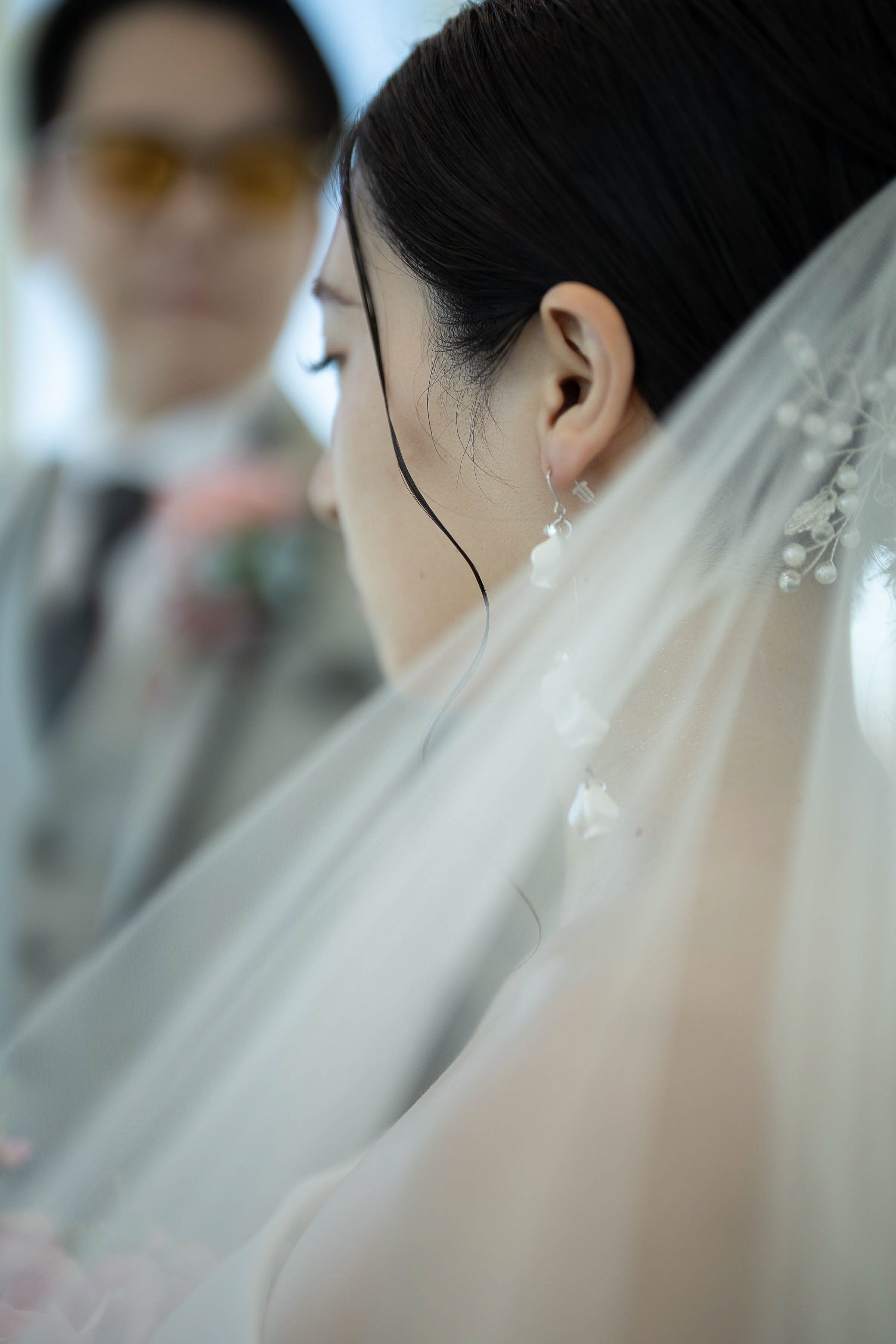 ベール越しに捉えた新婦の横顔とイヤリング